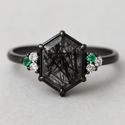 Skinny medium length Hexagon cut Black rutilated quartz with 1 emerald on each side and 3 moissanite on each side accent stones in a cluster on a black band