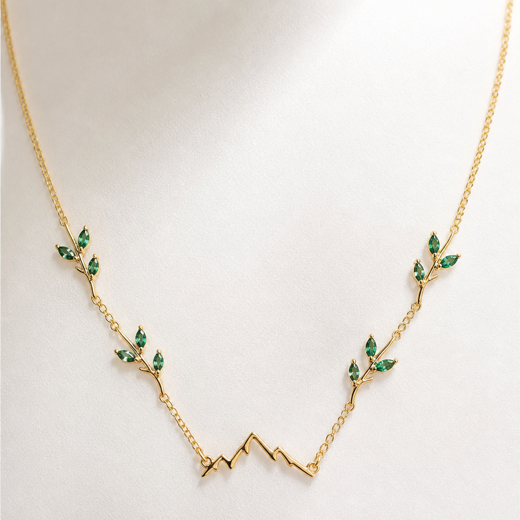 A minimalist women's necklace made of gold with emerald stones suitable for anniversary. un collar con gemas pequeñas tipo hojas y al final en frente una montaña
photorealistic jewelry design, A minimalist women's necklace made of gold with emerald stones suitable for anniversary. un collar con gemas pequeñas tipo hojas y al final en frente una montaña, minimalist style, just the design no text