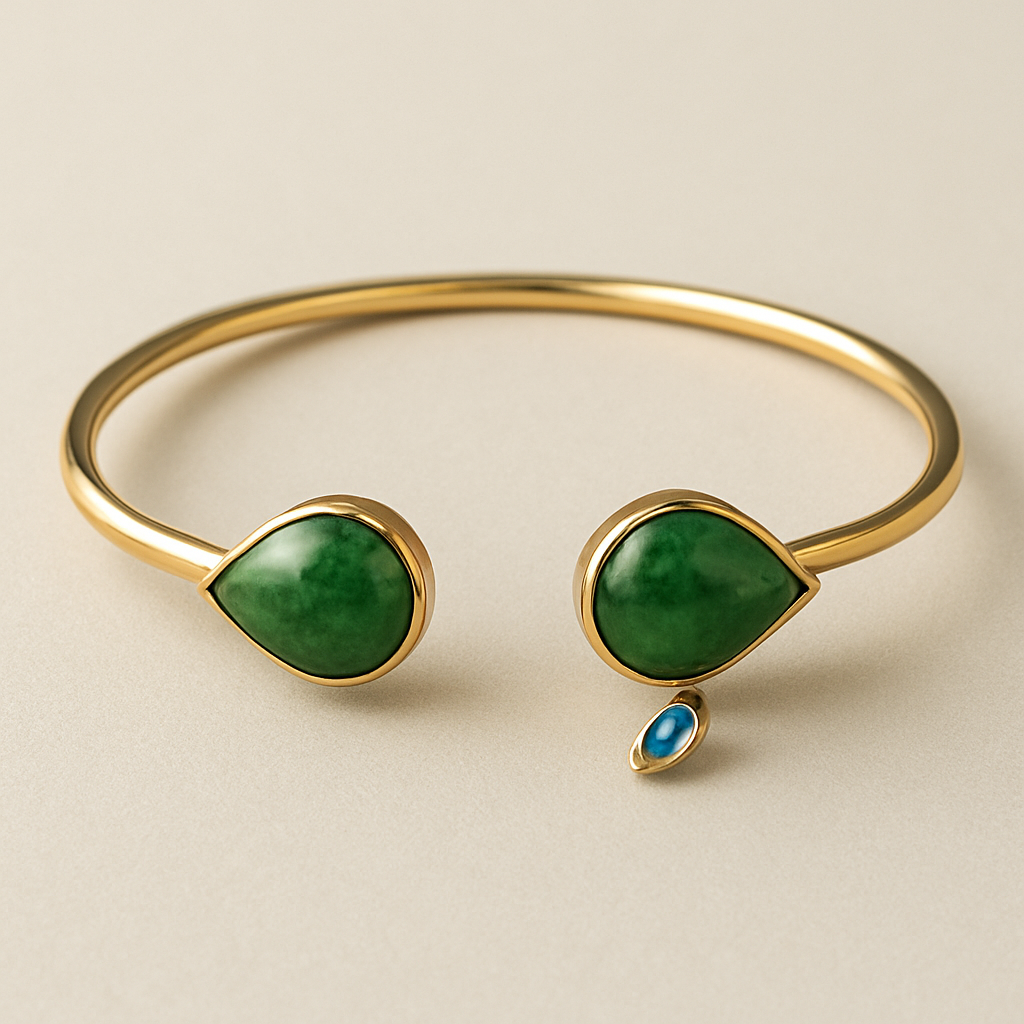 Create a yellow gold cuff with two pear shaped pieces of nephrite jade at the ends and two petite pear shaped blue topaz’s set in the gold of the bracelet