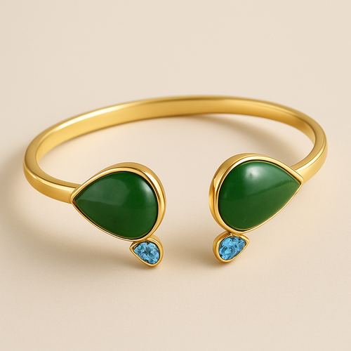 Create a yellow gold cuff with two pear shaped pieces of nephrite jade at the ends and two petite pear shaped blue topaz’s set in the gold of the bracelet