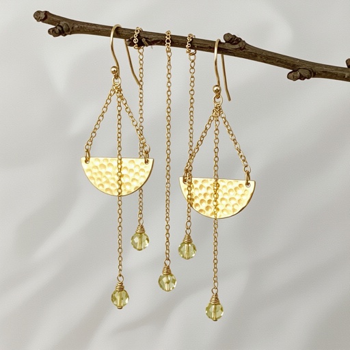 Золотые серьги словно мятое золото в форме узкого изящного полумесяца. Верхушка полумесяца крепится к застежке серьги.  От полумесяца идет три цепочки, у каждой на конце мелкий камушек цитрин