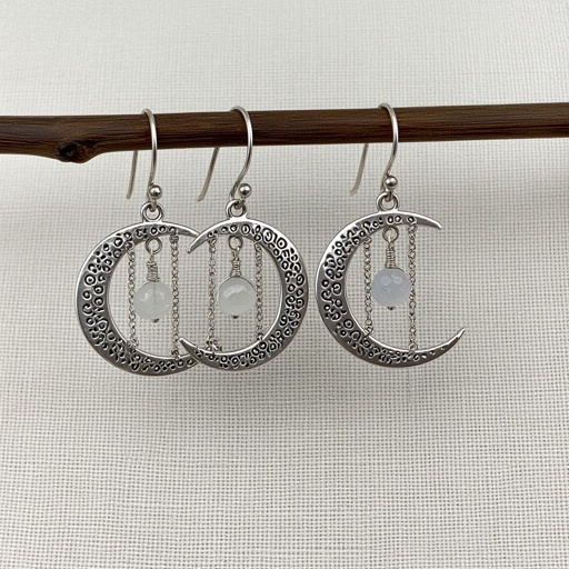 Серебряные серьги словно мятое сер ебро в форме полумесяца. Верхушка полумесяца крепится к застежке серьги.  От полумесяца идет три цепочки, у каждой на конце мелкий камушек лунный камень