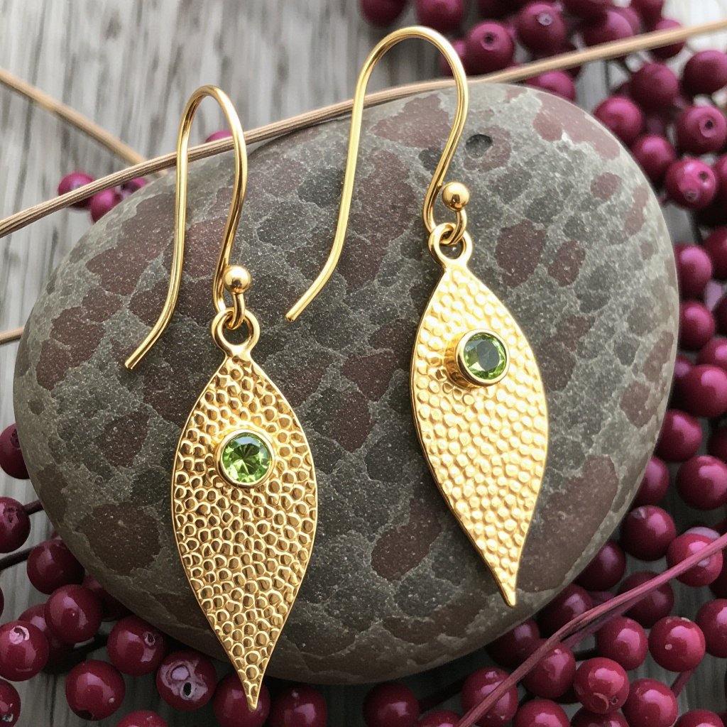 Серьги длинные на цепочках матовое золото мятое. Символ листок с прожилками на нем маленькие зеленые  камушки
