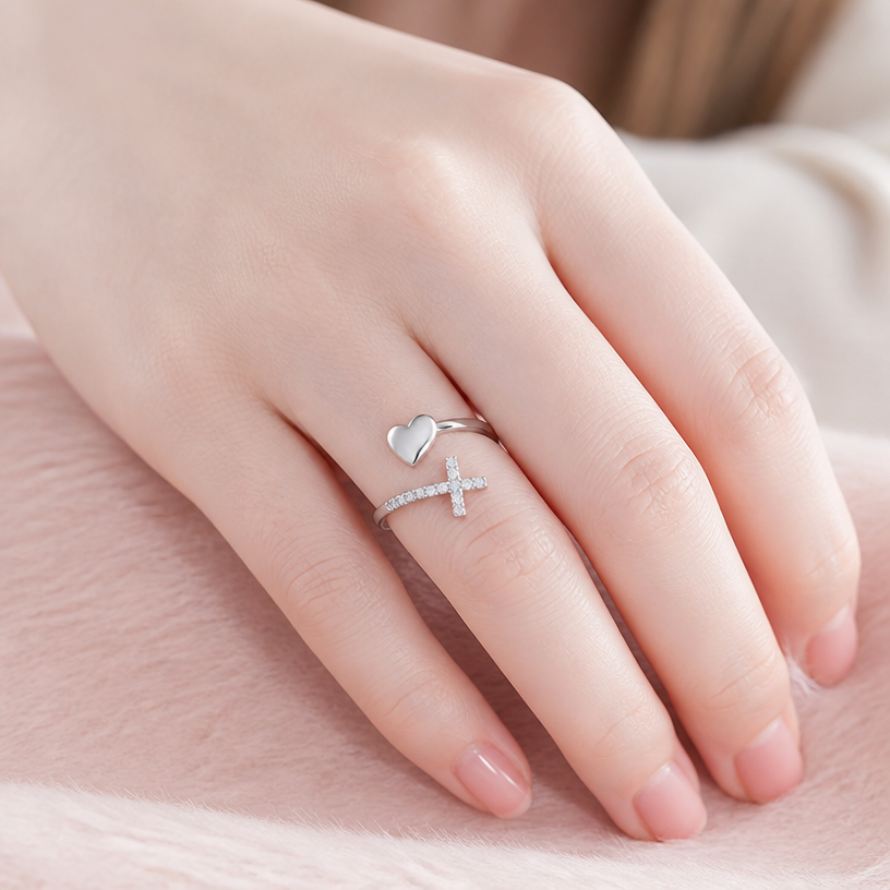 Jewelry photoshoot (worn)
Show the jewelry piece from the image worn by an elegant model in a professional editorial photograph, soft studio lighting. Reproduce the jewelry's exact design, metal, stones and details faithfully. Photorealistic, no text. Additional instructions: Close-up lifestyle photograph of a female model with very fair skin tone wearing the adjustable sterling silver heart and cross ring. Her hand is gently resting on a soft pastel surface. Daylight, natural pose. The focus is sharp on the ring details (heart and CZ cross). High quality, elegant aesthetics..