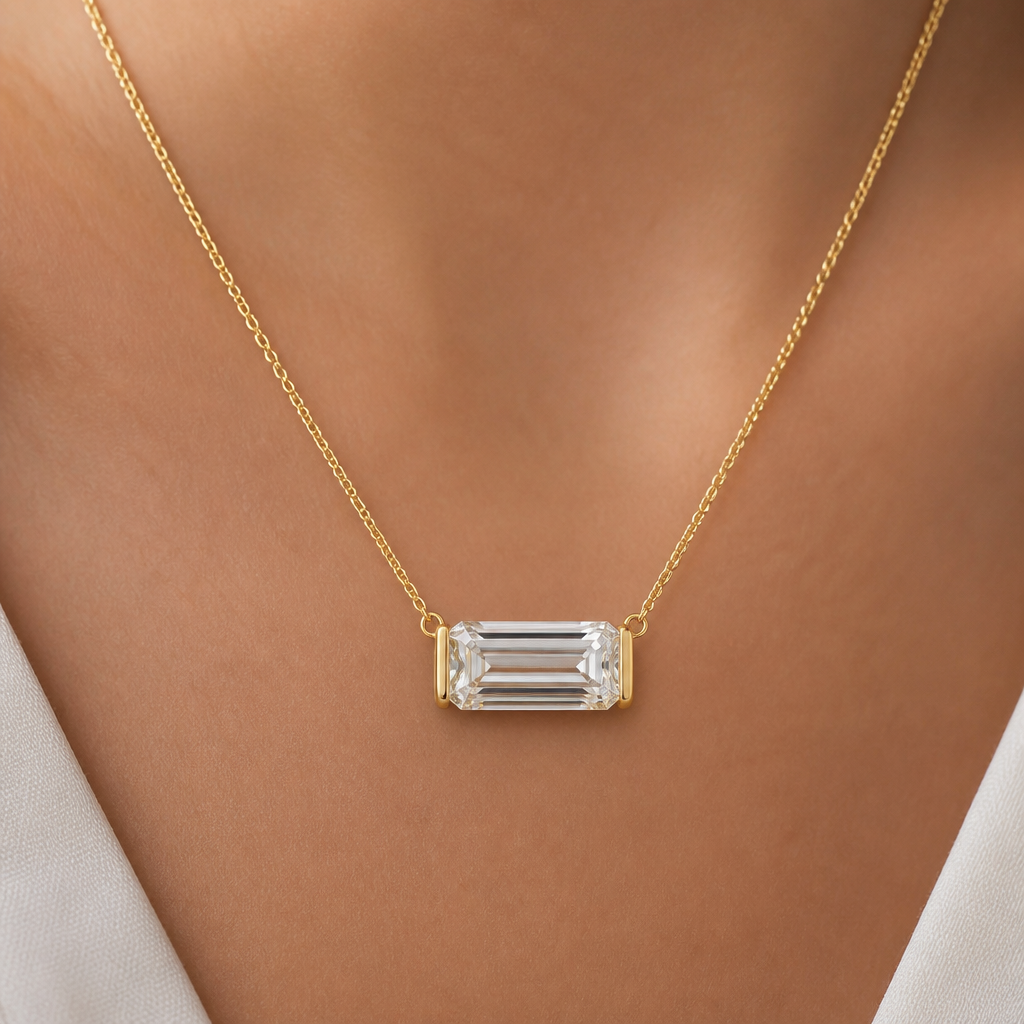 10ct emerald cut diamond pendant that can be placed on different chains. It has a small loop to thread chains through. The diamond is east west. Can show it on a 14inch necklace. All of the metal is yellow gold. Half bezel not prongs. Bezel is thin and only on the left and right sides, not top and bottom
photorealistic jewelry design, 10ct emerald cut diamond pendant that can be placed on different chains. It has a small loop to thread chains through. The diamond is east west. Can show it on a 14inch necklace. All of the metal is yellow gold. Half bezel not prongs. Bezel is thin and only on the left and right sides, not top and bottom, minimalist style, just the design no text