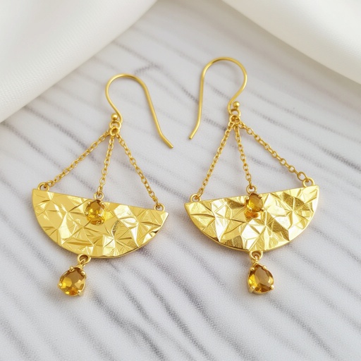 Золотые серьги словно мятое золото в форме узкого изящного полумесяца. Верхушка полумесяца крепится к застежке серьги.  От полумесяца идет три цепочки, у каждой на конце мелкий камушек цитрин