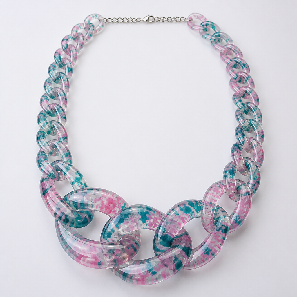 A women's necklace. create a chunky Cuban Link style plastic chain that is o graduated and exaggerated in the first front three links that is translucent confetti lucite of teal and pink
photorealistic jewelry design, A women's necklace. create a chunky Cuban Link style plastic chain that is o graduated and exaggerated in the first front three links that is translucent confetti lucite of teal and pink, modern style, just the design no text