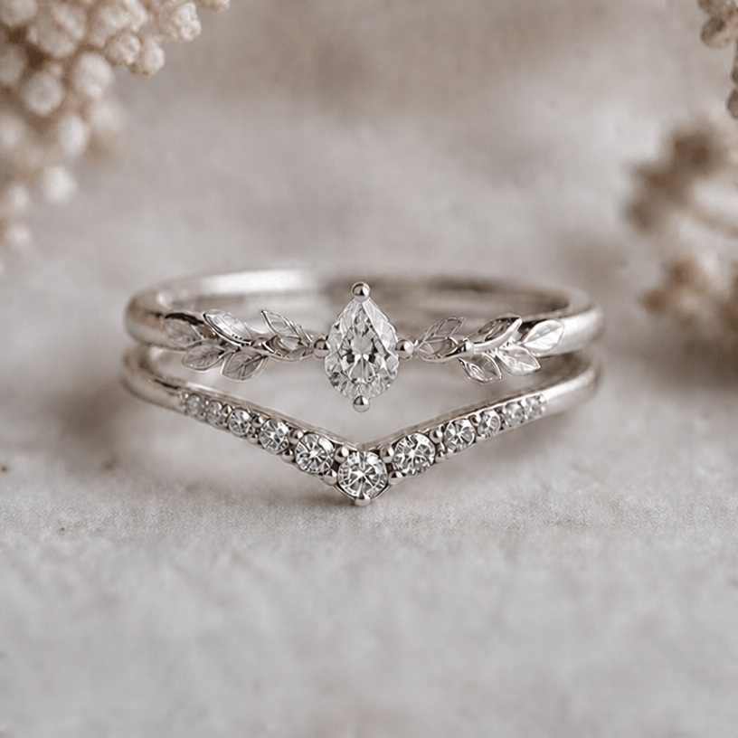 Change the shape of the main stone of the upper ring into a drop shape
edit the attached jewelry design with these instructions: Change the shape of the main stone of the upper ring into a drop shape. keep it photorealistic, just the design no text