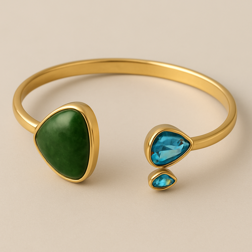 Create a yellow gold cuff with two pear shaped pieces of nephrite jade at the ends and two petite pear shaped blue topaz’s set in the gold of the bracelet