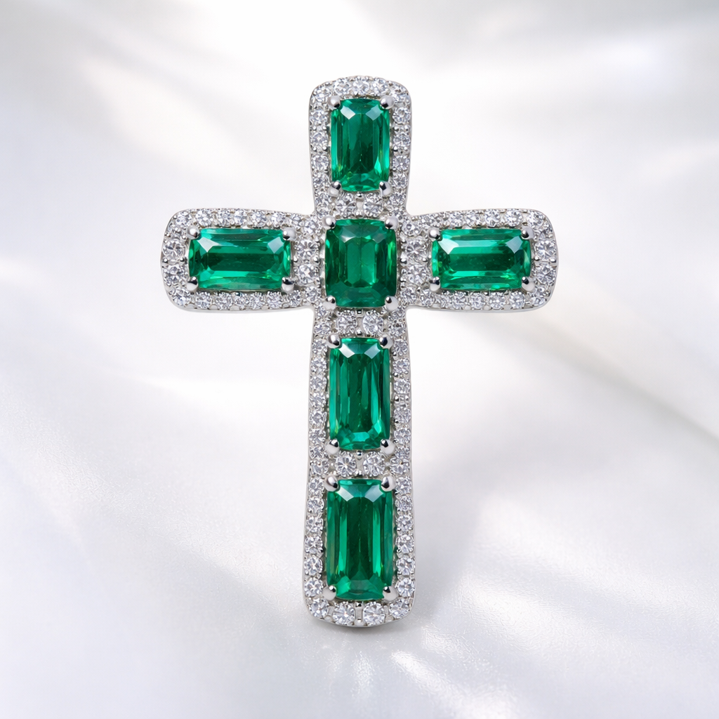 Emerald white gold cross and with simple diamond accent stones. Timeless, elegant, and classy. Hidden bail.