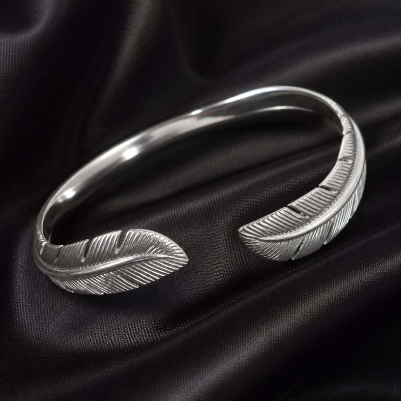 A women's ring made of silver. feather around bracelet
using the attached image as a visual reference, create A women's ring made of silver. feather around bracelet. photorealistic, just the design no text