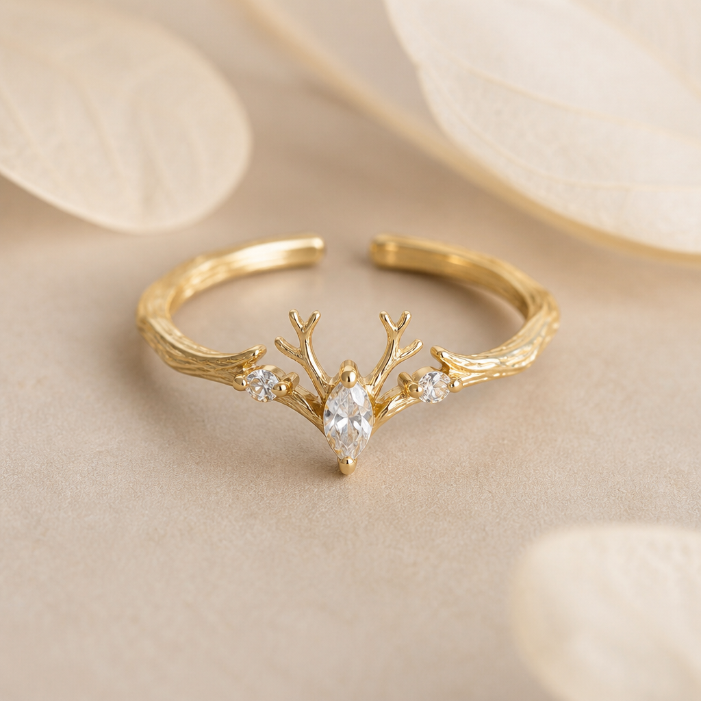 A nature-inspired women's ring made of gold with diamond stones suitable for daily wear. A delicate deer inspired open ring with opening at the bottom so it's adjustable. It has a small lemon shaped american diamond in the center with 2 small antlers at the top and 2 american diamonds at both the sides. The band is antlers inspired. It's a minimal nature inspired ring.
photorealistic jewelry design, A nature-inspired women's ring made of gold with diamond stones suitable for daily wear. A delicate deer inspired open ring with opening at the bottom so it's adjustable. It has a small lemon shaped american diamond in the center with 2 small antlers at the top and 2 american diamonds at both the sides. The band is antlers inspired. It's a minimal nature inspired ring., nature_inspired style, just the design no text