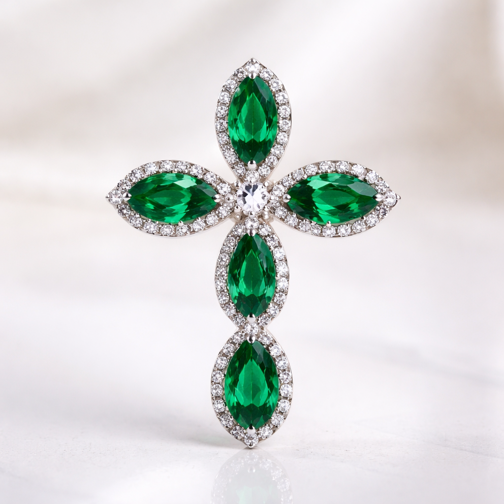 Pear cut emerald cross on 14k white gold with bale attached to the back and not shown. Few diamond accent stones. Classic, simple, and elegant