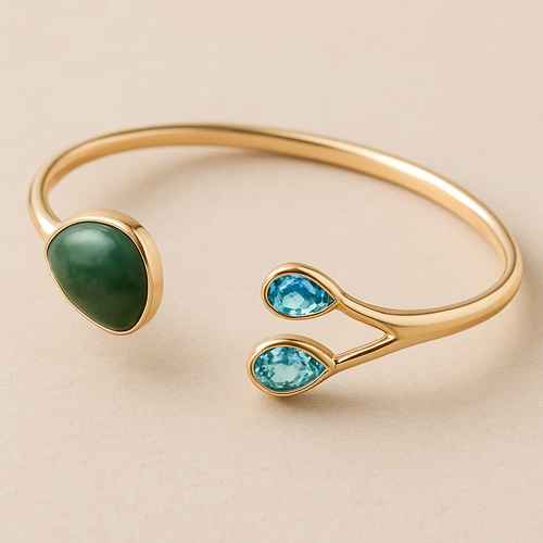 Create a yellow gold cuff with two pear shaped pieces of nephrite jade at the ends and two petite pear shaped blue topaz’s set in the gold of the bracelet