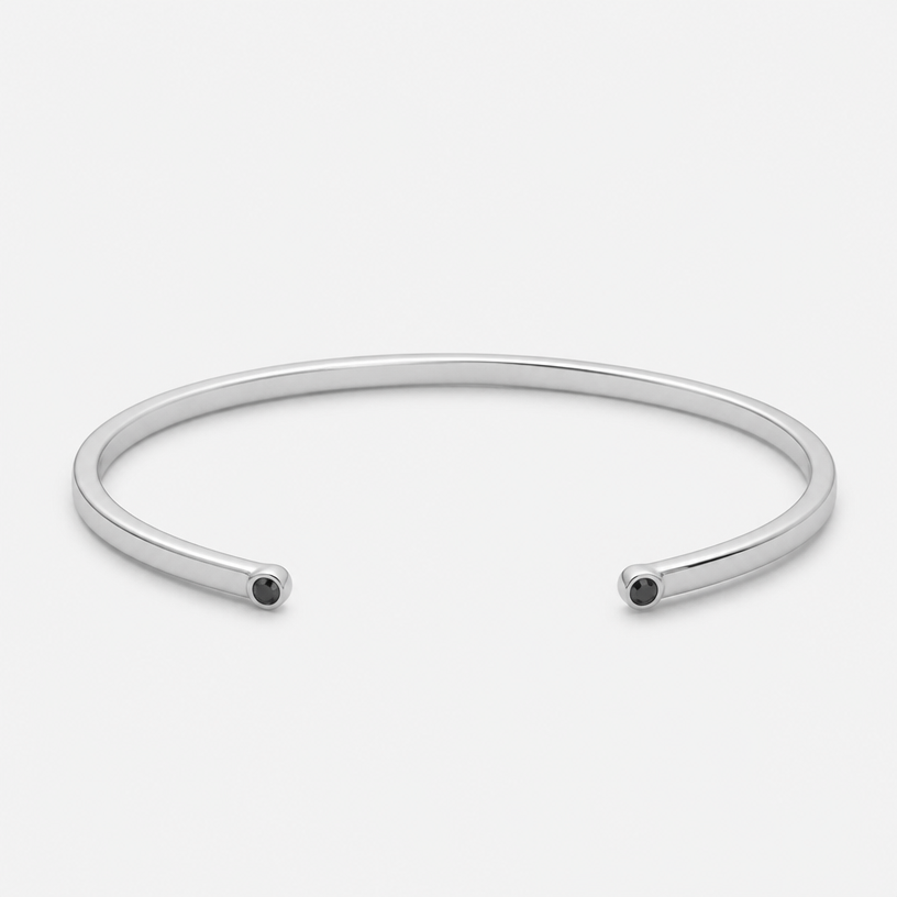 A women's bracelet made of silver. a 3mm wire bracelet with 2 black stone ingraved in the 2 tips of the bracelet
using the attached image as a visual reference, create A women's bracelet made of silver. a 3mm wire bracelet with 2 black stone ingraved in the 2 tips of the bracelet. photorealistic, just the design no text