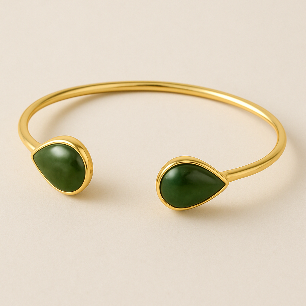 Create a yellow gold cuff with two pear shaped pieces of nephrite jade at the ends and two petite pear shaped blue topaz’s set in the gold of the bracelet