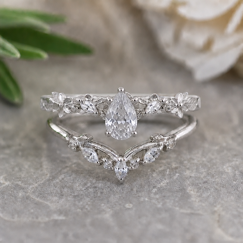 Please change the main stone of the upper ring into a fine drop form
edit the attached jewelry design with these instructions: Please change the main stone of the upper ring into a fine drop form. keep it photorealistic, just the design no text