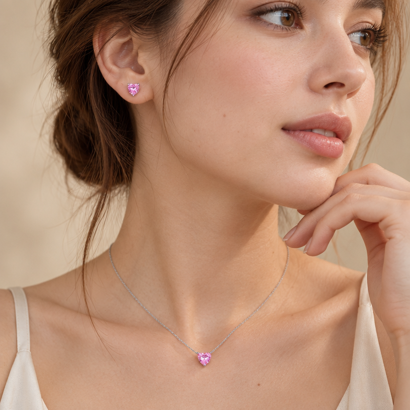 Jewelry photoshoot (worn)
Show the jewelry piece from the image worn by an elegant model in a professional editorial photograph, soft studio lighting. Reproduce the jewelry's exact design, metal, stones and details faithfully. Photorealistic, no text. Additional instructions: "Close-up beauty/editorial photo of a woman with fair light skin, hand gently raised near her chin/jawline in a relaxed, natural pose, head gently turned to show her neck, collarbone, and ear. Soft, warm neutral studio background (beige/cream tones), softly blurred, shallow depth of field.
She wears a sterling silver necklace with a heart-shaped pink cubic zirconia pendant set in a simple four-prong setting, and a matching heart-shaped pink cubic zirconia stud earring.
METAL FINISH: the sterling silver must be rhodium-plated — bright, cool-white, and reflective with a polished mirror-like shine, not dull or matte. The metal should catch light naturally, without looking overly glossy, plastic, or artificially glowing.
STONE DETAIL: the pink heart-cut cubic zirconia stones must be vivid pink, sparkling, and perfectly faceted with a clean heart shape, catching light realistically with natural sparkle and brilliance — not flat or dull.
SKIN REALISM REQUIREMENT: skin must look completely natural and photorealistic — fair, light skin tone with visible fine skin texture, natural pores, subtle imperfections. Avoid any smooth, plastic, airbrushed, CGI, or overly retouched look. Lighting soft and warm, casting natural gentle shadows.
STRICT SIZE REQUIREMENT: use the reference image only to understand the correct real-life scale of the jewelry — the pendant must be exactly 0.7cm height, and the earring exactly 0.6cm height, true to scale against the neck and ear. Do not enlarge or oversize.
CHAIN AND PENDANT POSITION: fine cable chain draping naturally in a soft V-shape along the collarbone, with the heart pendant hanging centered at the lowest point of the chain, point of the heart facing down, attached by a small prong setting at the top.
Mood: elegant, minimal, intimate — high-end jewelry brand photography style, sharp focus on the jewelry while keeping the composition natural and soft.
METAL FINISH: the sterling silver must be rhodium-plated — bright, cool-white, and reflective with a polished mirror-like shine, not dull or matte. The metal should catch light naturally, without looking overly glossy, plastic, or artificially glowing.
STONE DETAIL: the pink heart-cut cubic zirconia stones must be vivid pink, sparkling, and perfectly faceted with a clean heart shape, catching light realistically with natural sparkle and brilliance — not flat or dull.
SKIN REALISM REQUIREMENT: skin must look completely natural and photorealistic — visible fine skin texture, natural pores, subtle imperfections, soft even tone. Avoid any smooth, plastic, airbrushed, CGI, or overly retouched look. Lighting soft and warm, casting natural gentle shadows.
STRICT SIZE REQUIREMENT: the pendant must be exactly 0.7cm height, and the earring exactly 0.6cm height, true to real-life scale against the neck and ear — do not enlarge or oversize.
CHAIN AND PENDANT POSITION: fine cable chain draping naturally in a soft V-shape along the collarbone, with the heart pendant hanging centered at the lowest point of the chain, point of the heart facing down, attached by a small prong setting at the top.
Background a warm blurred neutral tone (cream/beige), shallow depth of field. Mood: elegant, minimal, intimate — natural high-end jewelry brand photography style, matching the reference close-up shot.
FORMAT: generate this image in Instagram Post format, square aspect ratio 1:1 (1080x1080px), with the jewelry and face composition centered and balanced within the frame..
