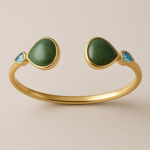 Create a yellow gold cuff with two pear shaped pieces of nephrite jade at the ends and two petite pear shaped blue topaz’s set in the gold of the bracelet