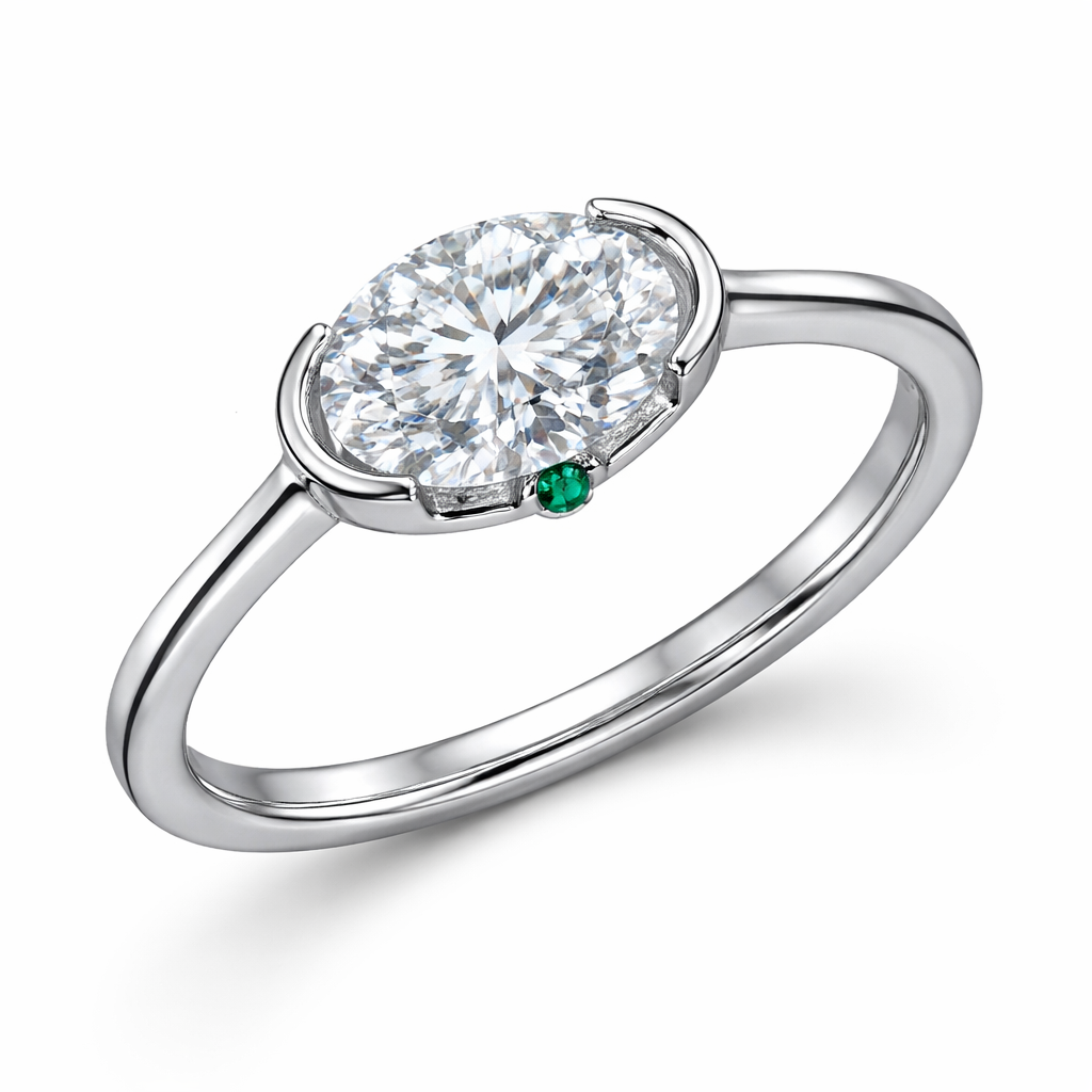 Center Stone
• Diamond: lab-grown
• Carat: ~2.0 ct
• Shape: oval brilliant
• Orientation: east–west (horizontal)
• Setting: negative-space bezel (partial bezel with open support arm)
• Position: slightly offset to the left
• 1 micro emerald
• size: ~1.2 mm
• placement: centered in the gallery under the diamond
Band
• Metal: platinum
• Style: knife-edge band
• Width: 1.6 mm