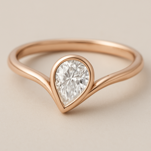 A refined 0.50 diamond  pinky ring and elegant rose gold ring featuring a pear-shaped diamond set in a smooth bezel setting. The diamond is tilted slightly to the side, creating a paisley-inspired shape reminiscent of a graceful flowing droplet. The rose gold band is sleek and polished, complementing the organic, curving silhouette of the stone. The design blends modern minimalism with a subtle artistic twist inspired by the Bandana paisley motif.