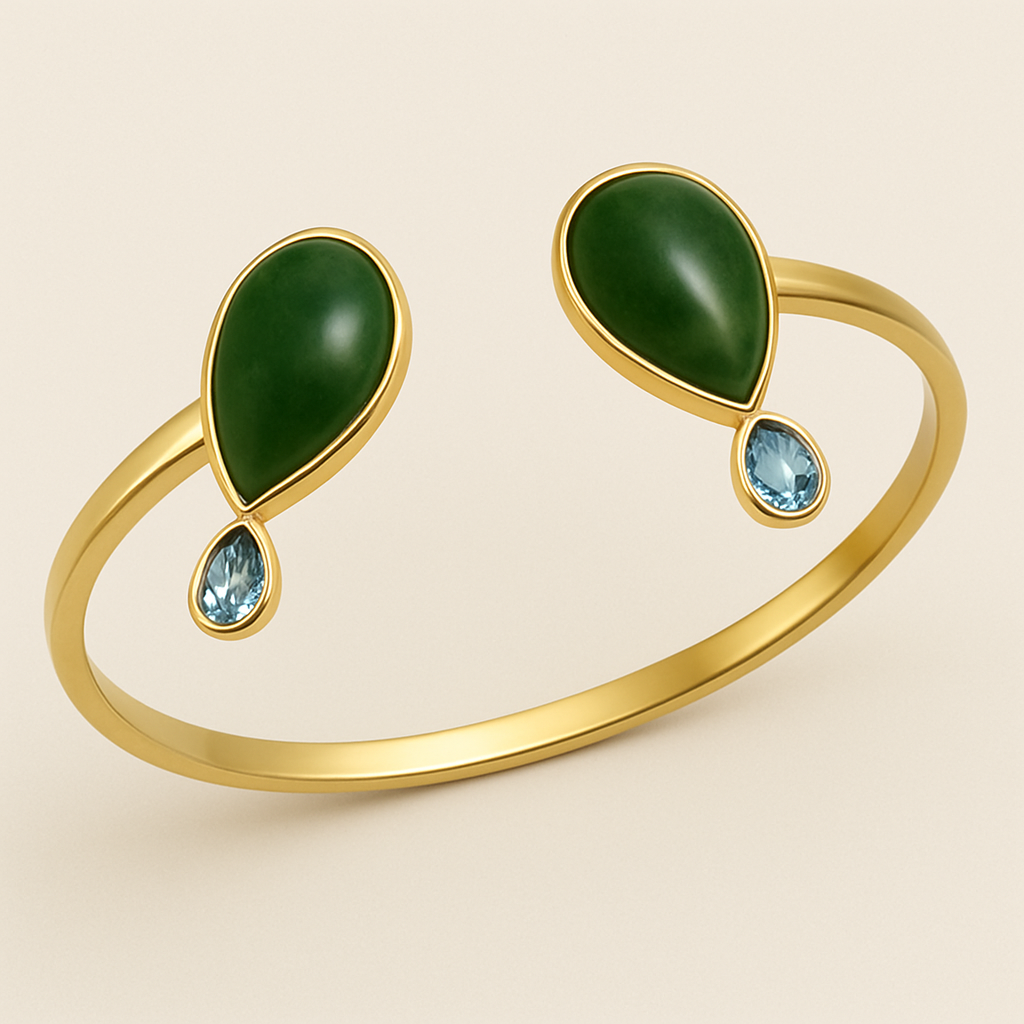 Create a yellow gold cuff with two pear shaped pieces of nephrite jade at the ends and two petite pear shaped blue topaz’s set in the gold of the bracelet