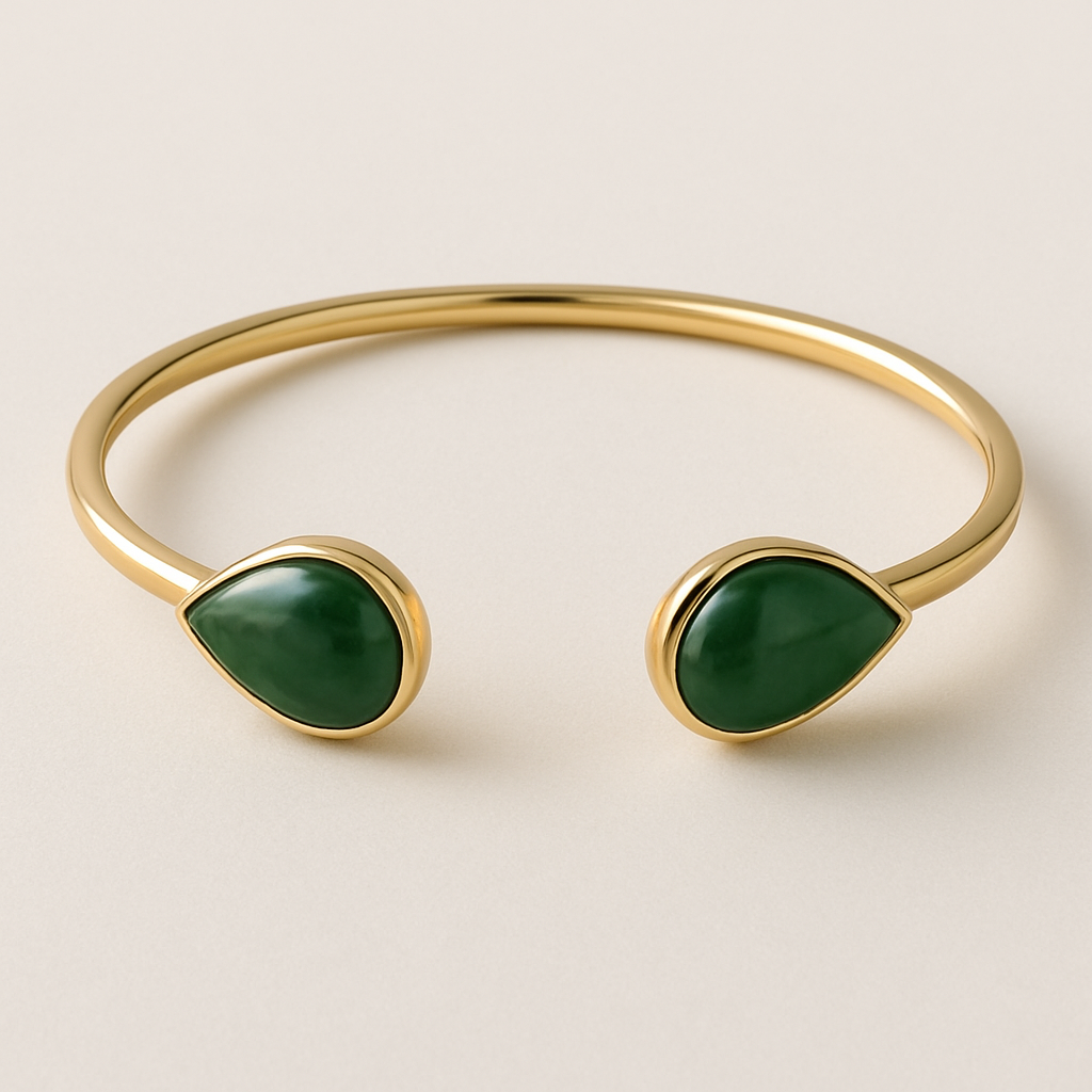 Create a yellow gold cuff with two pear shaped pieces of nephrite jade at the ends and two petite pear shaped blue topaz’s set in the gold of the bracelet