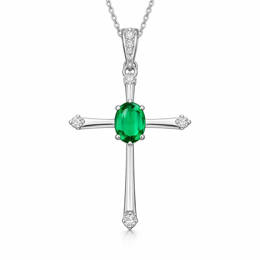 Oval cut emerald, white gold cross with minimal diamond accent stones. Minimal metal work.