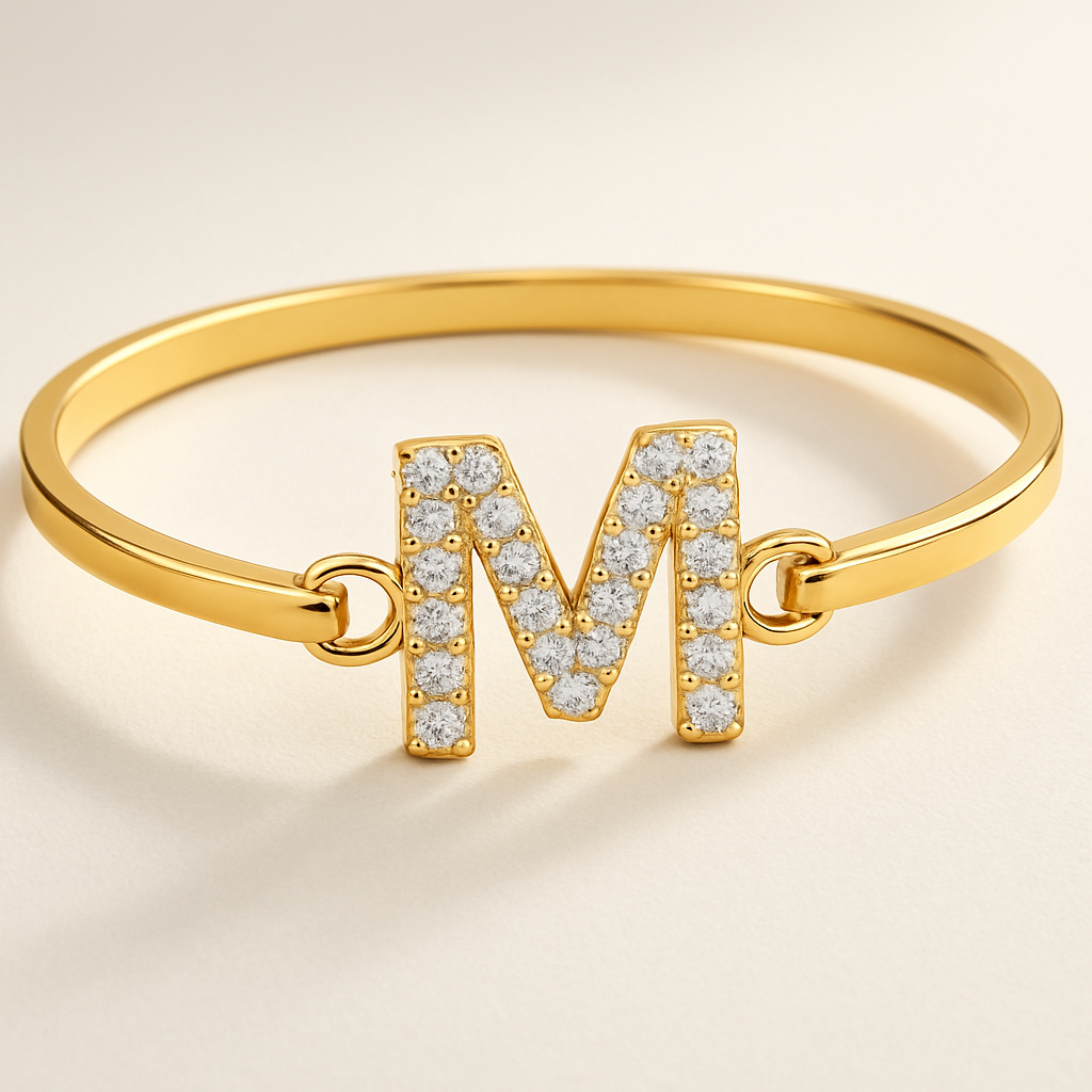 Armband in het goud en dan een letter M in het midden in diamanten