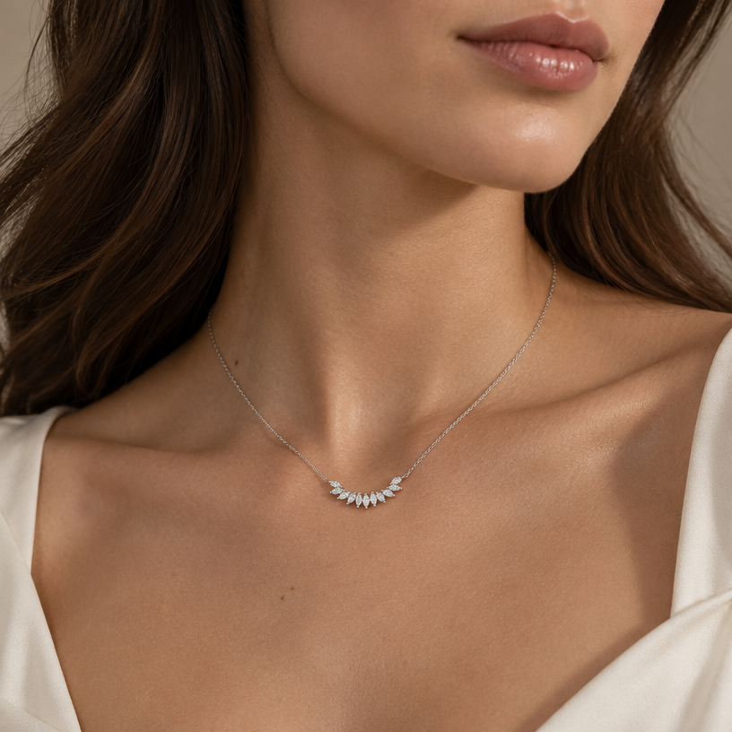 Jewelry photoshoot (worn)
Show the jewelry piece from the image worn by an elegant model in a professional editorial photograph, soft studio lighting. Reproduce the jewelry's exact design, metal, stones and details faithfully. Photorealistic, no text. Additional instructions: Close-up, minimalist, aesthetic fashion photograph focusing on a woman's dark skin collarbone and neck area against a neutral background. She is wearing an extremely delicate, thin gold chain necklace. The central element on the chain is a minuscule, very small, dainty curved arc of tiny sparkling diamond studs, rendered in a much smaller scale for a hyper-minimalist look. The small pendant is a subtle accent on the skin, not a dominant piece. Natural, warm directional lighting highlights the rich skin texture and creates deep, beautiful shadows, with minimal film grain. High-resolution, cinematic, elegant composition. "A woman with white skin and loose hair draping down her back and sides. A medium-sized jewelry piece." "A woman with white skin and loose hair draping down her back and sides. A medium-sized jewelry piece featuring a silver necklace with a fully silver chain.".
