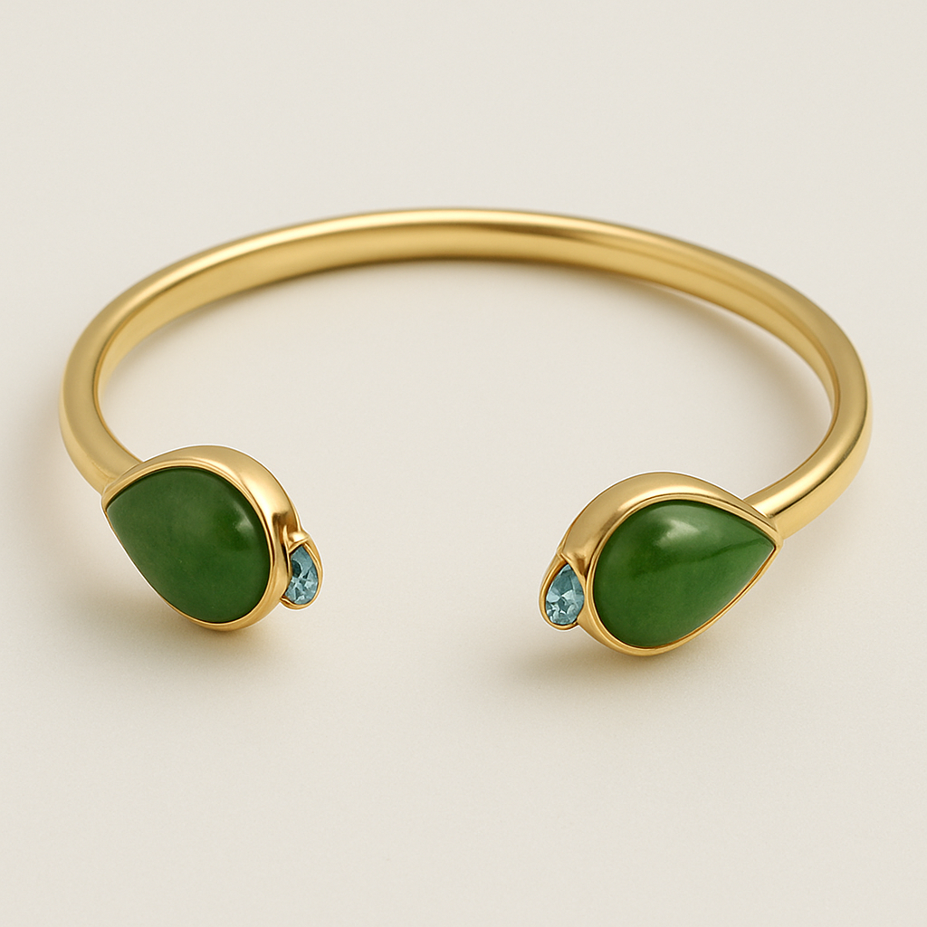 Create a yellow gold cuff with two pear shaped pieces of nephrite jade at the ends and two petite pear shaped blue topaz’s set in the gold of the bracelet