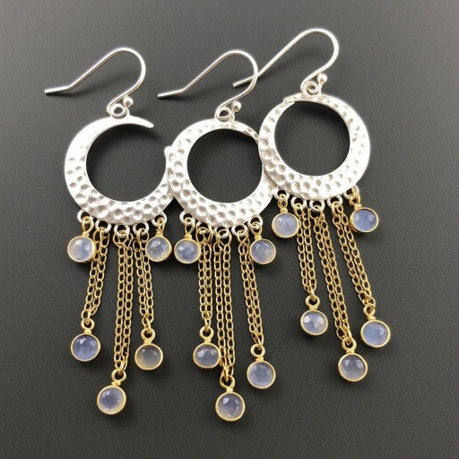 Серебряные серьги словно мятое серебро в форме полумесяца вертикальныйсверху крепится к швензе. От полумесяца идет три цепочки золотого цвета, у каждой на конце мелкий камушек лунный камень