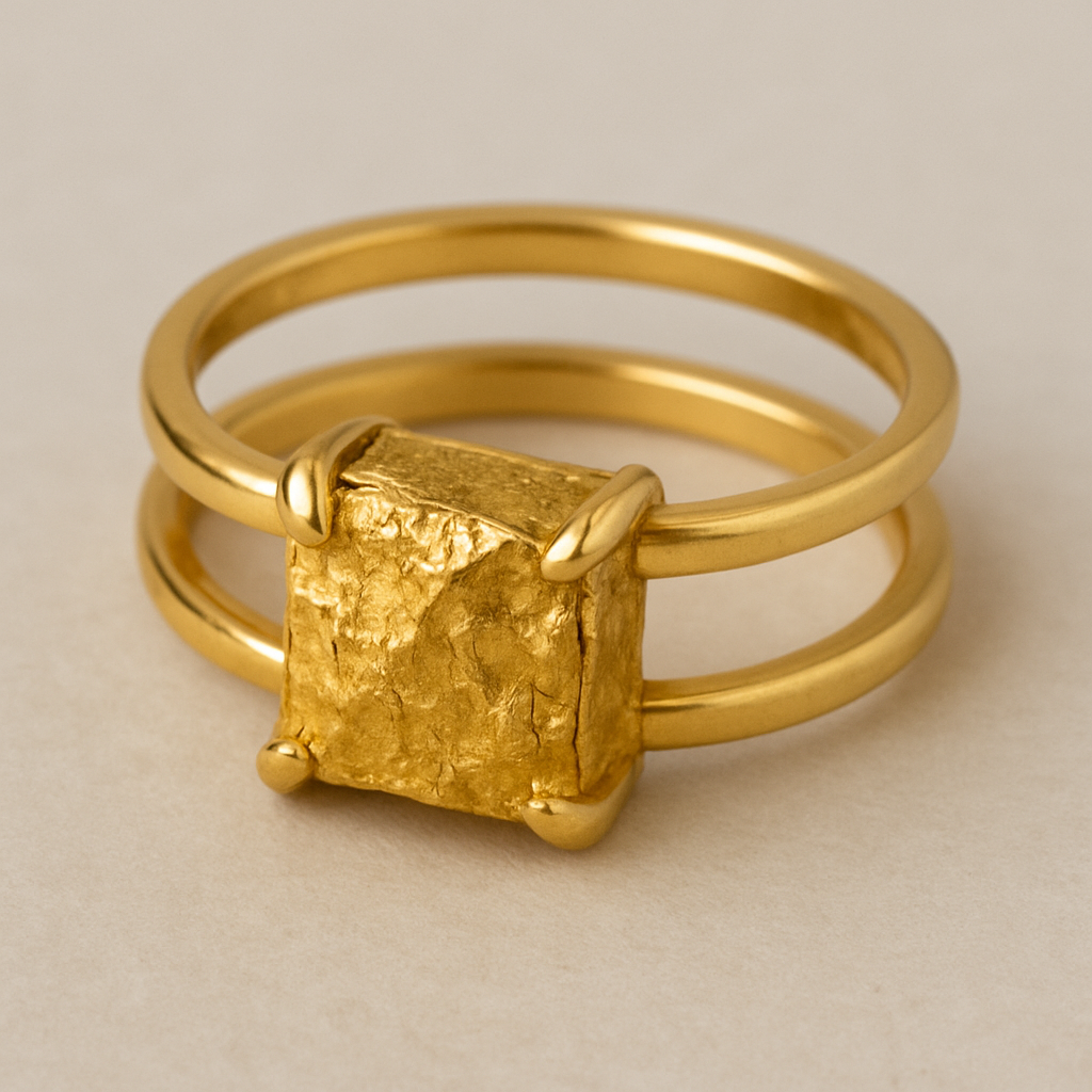 Split ring bands connected in middle behind finger with a prong setting of raw gold nugget shaped like a square