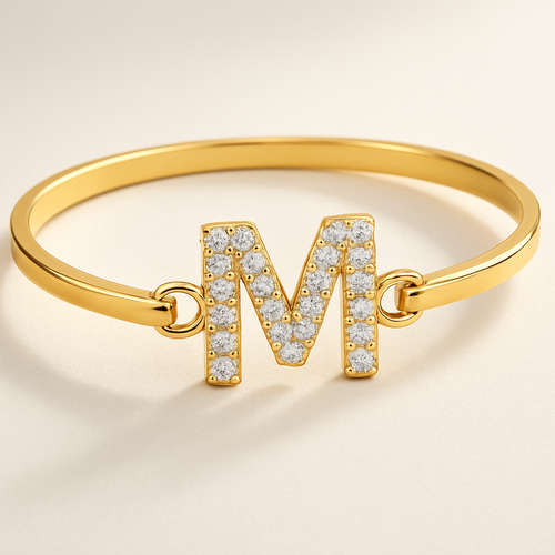 Armband in het goud en dan een letter M in het midden in diamanten