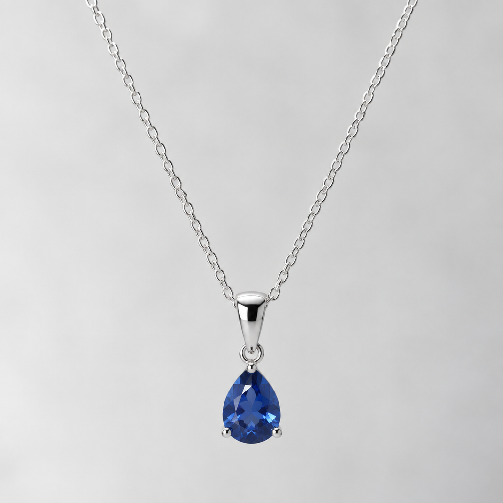 A realistic sterling silver necklace with a delicate chain, a small blue sapphire pendant, polished silver, elegant and minimal, professional jewelry product photography.
photorealistic jewelry design, A realistic sterling silver necklace with a delicate chain, a small blue sapphire pendant, polished silver, elegant and minimal, professional jewelry product photography., just the design no text