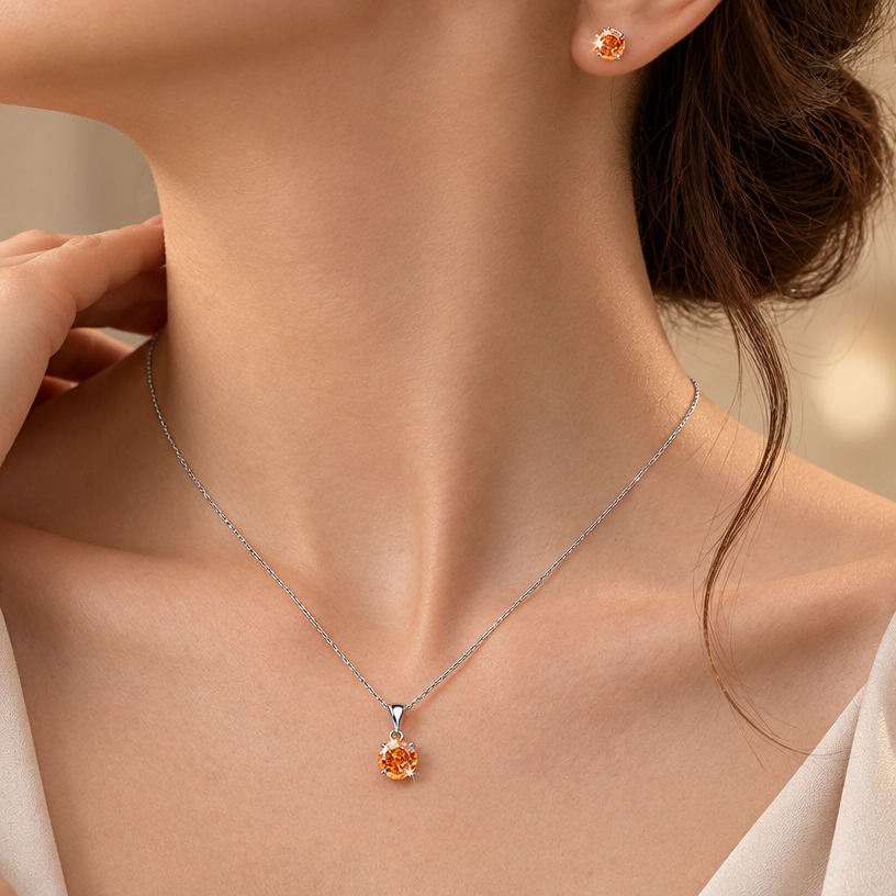 Jewelry photoshoot (worn)
Show the jewelry piece from the image worn by an elegant model in a professional editorial photograph, soft studio lighting. Reproduce the jewelry's exact design, metal, stones and details faithfully. Photorealistic, no text. Additional instructions: "Close-up editorial jewelry photo of a woman's neck, collarbone, ear, and upper chest, cropped so the face is fully out of frame. She wears soft, elegant clothing, only a small part of the fabric visible at the edge of the frame.
VARY THE POSE: do not repeat the same head tilt, shoulder position, or framing as previous generations. Use natural variations such as: head turned left or right, chin slightly up or down, one shoulder raised or relaxed, hair swept to either side or tucked back, camera angle shifted slightly higher or lower. Keep the framing tight on the neck, collarbone, and ear (face always out of frame), but make the pose feel distinct and natural.
She wears a sterling silver necklace with a round, multi-faceted orange/amber cubic zirconia pendant (cut with a spiral, rose-flower faceted pattern) set in a four-prong setting, and a matching pair of round faceted orange cubic zirconia stud earrings with the same spiral rose-cut faceting.
METAL FINISH: the sterling silver must be rhodium-plated — bright, cool-white, and reflective with a polished mirror-like shine, not dull or matte. The metal should catch light naturally, without looking overly glossy, plastic, or artificially glowing.
STONE COLOR AND DETAIL: the cubic zirconia stones must be a vivid orange-amber color, sparkling and perfectly faceted with a distinctive spiral rose-cut pattern, catching light realistically with natural brilliance and multiple light reflections.
STRICT SIZE REQUIREMENT: the pendant (including bail) must be exactly 2cm height, and the earrings exactly 0.6cm each, true to real-life scale against the neck, collarbone, and ear. Do not enlarge or oversize — the pendant should look elegant on the chest, not bulky or overly large.
SKIN REALISM REQUIREMENT: skin must look completely natural and photorealistic — visible fine skin texture, natural pores, subtle imperfections, soft even tone. Avoid any smooth, plastic, airbrushed, CGI, or overly retouched look. Lighting soft and warm, casting natural gentle shadows.
CHAIN AND PENDANT POSITION: fine cable chain draping naturally in a soft V-shape along the collarbone, with the round pendant hanging centered at the lowest point of the chain, attached by a teardrop-shaped bail. The stud earrings sit naturally and securely on the earlobes, fully visible and in focus.
Background softly blurred, warm and neutral, shallow depth of field. Mood: elegant, minimal, intimate — natural high-end jewelry brand photography style, face not shown, jewelry clearly and accurately rendered in true color and correct scale..