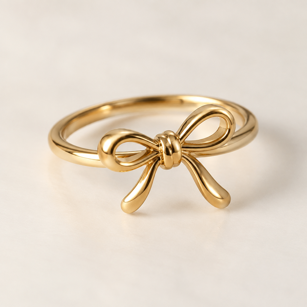 A minimalist women's ring made of gold suitable for gift. ring with the aesthetic ribbon design and the ribbon is tilting to right a bit. the ring goes around the ribbon not under the ribbon. the ribbon is tied like a double knot and the ribbon has two same size loops. the ribbon is rounded design not flat and both of the ribbon tails is a little bit bendy
photorealistic jewelry design, A minimalist women's ring made of gold suitable for gift. ring with the aesthetic ribbon design and the ribbon is tilting to right a bit. the ring goes around the ribbon not under the ribbon. the ribbon is tied like a double knot and the ribbon has two same size loops. the ribbon is rounded design not flat and both of the ribbon tails is a little bit bendy, minimalist style, just the design no text