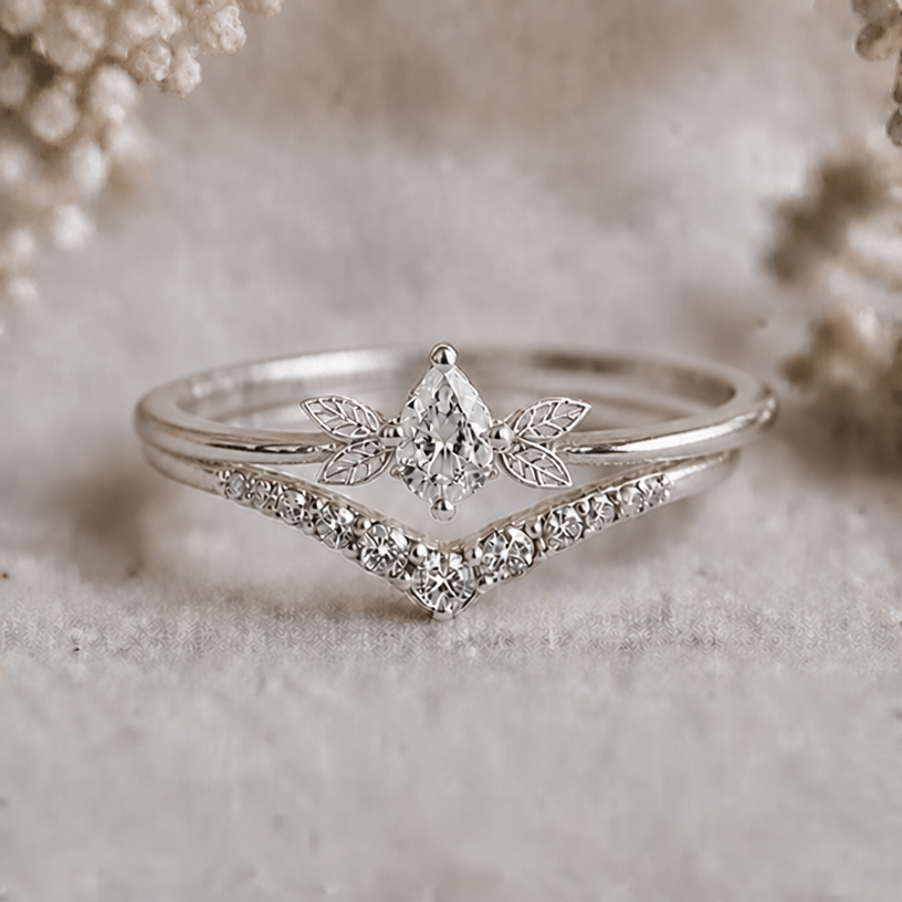 Keep only the leaves (two on each side) right next to the main stone of the upper ring
edit the attached jewelry design with these instructions: Keep only the leaves (two on each side) right next to the main stone of the upper ring. keep it photorealistic, just the design no text