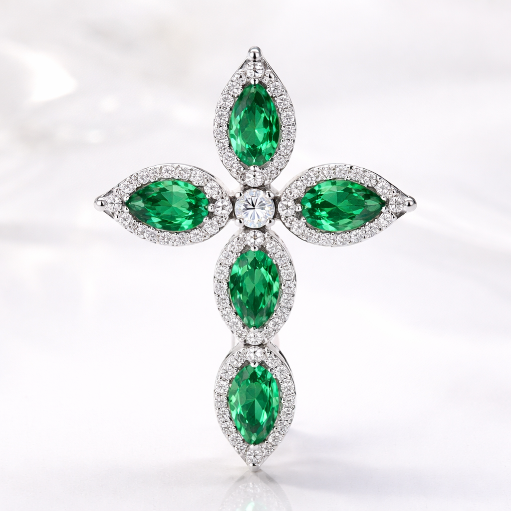 Pear cut emerald cross on 14k white gold with bale attached to the back and not shown. 5 diamond accent stones