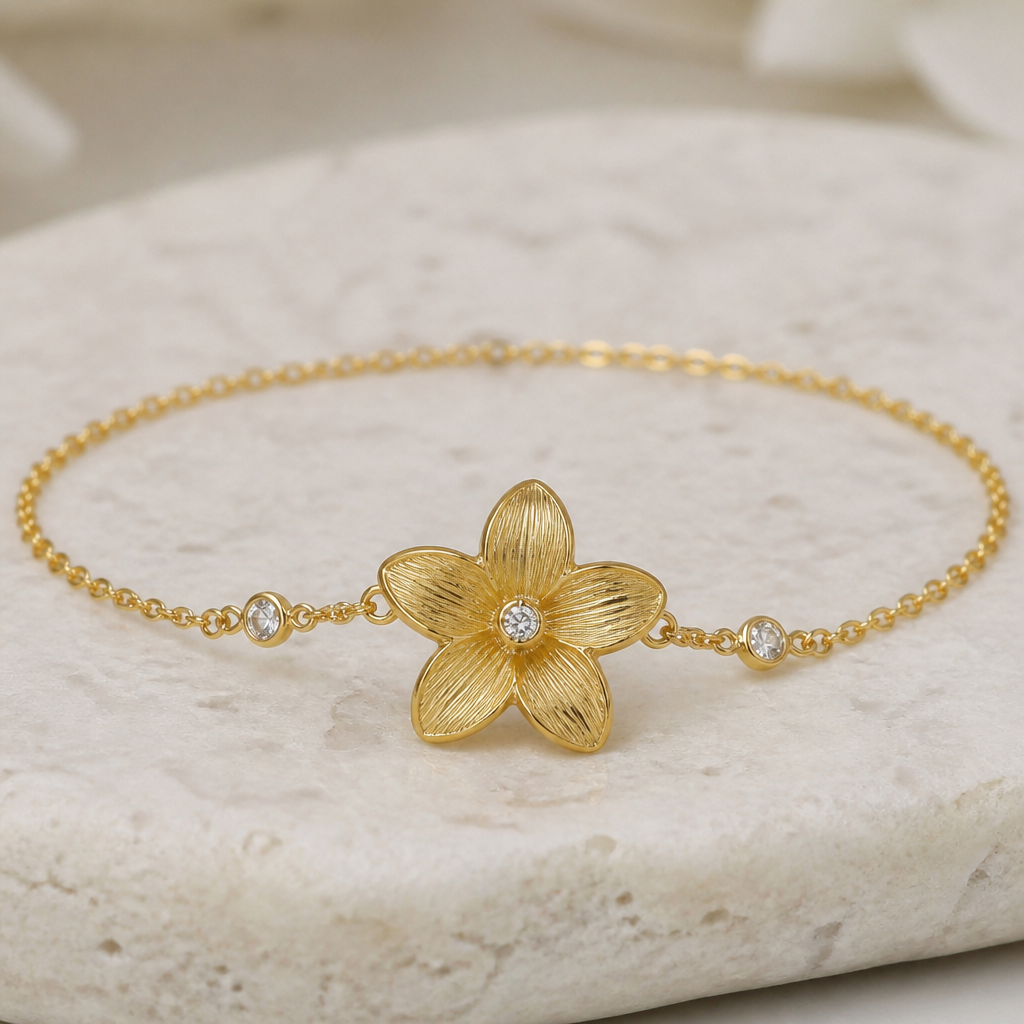 Can you create a gold based jasmine sambac flower with lines on the gold (one flower only) bracelet with a diamond in the middle and the bracelet is connected by a delicate chain with 2 tiny diamonds diamonds on the chain on each side of the bracelet