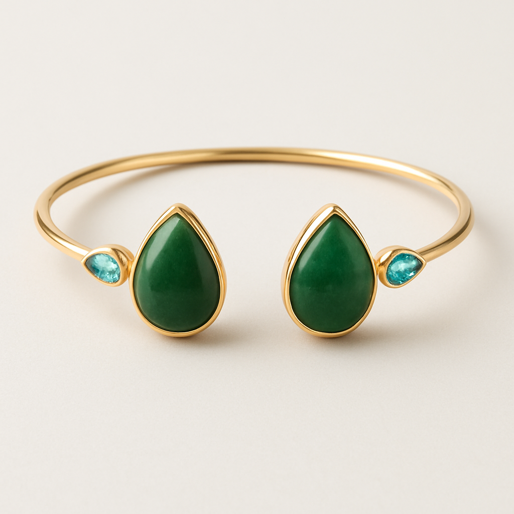 Create a yellow gold cuff with two pear shaped pieces of nephrite jade at the ends and two petite pear shaped blue topaz’s set in the gold of the bracelet