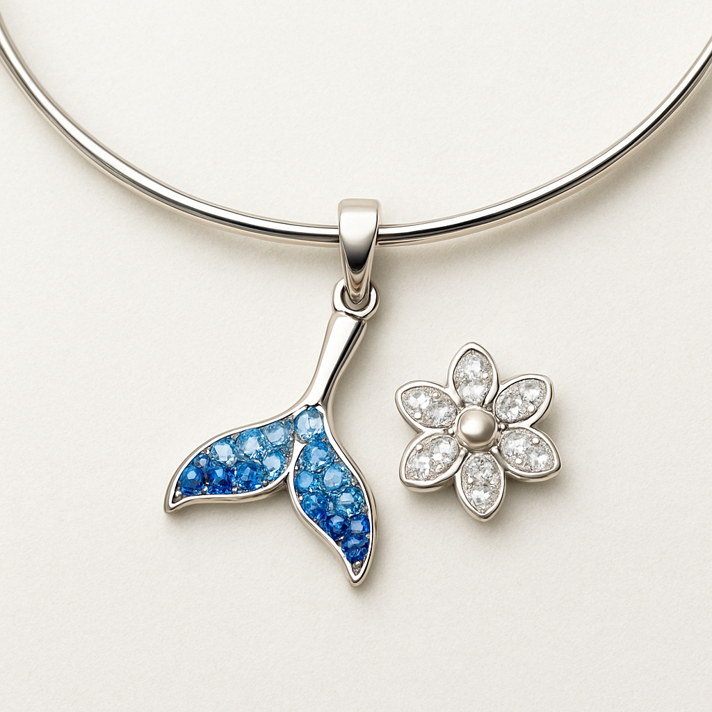 「泡沫尾光」「尾光绽放锁骨链」详细设计图文字说明
核心设计定位
以 “小美人鱼从鱼尾化为泡沫、光芒绽放” 为剧情核心，打造 “可翻转双形态” 锁骨链，兼顾日常佩戴实用性与剧情仪式感，突出 “轻盈璀璨、一饰两戴” 的特点。
1. 核心设计（双形态 + 剧情呼应）
形态一（鱼尾形态）：正面呈现银质镂空鱼尾轮廓，鱼尾边缘镶嵌渐变海蓝锆石（从浅蓝到深蓝，模拟海底深浅光影），鱼尾中心留白处刻迷你 “鱼尾 + 泡沫” 简化暗纹，呼应小美人鱼的海底身份。
形态二（泡沫绽放形态）：翻转吊坠后，呈现 “六瓣泡沫绽放” 造型，每片泡沫边缘镶嵌细闪白锆石（模拟尾光），中心镶嵌 1 颗圆形小珍珠（象征 “梦的结晶”），泡沫内侧刻 “Glow Forever” 英文小字（呼应 Slogan “尾光永存”）。
翻转结构：吊坠通过两侧微型铰链连接，可 360° 顺畅翻转，铰链处隐藏在泡沫花瓣与鱼尾轮廓的衔接处，不破坏整体视觉。
2. 尺寸参数（适配日常佩戴）
吊坠总尺寸：长 22mm× 宽 18mm（鱼尾形态）/ 直径 20mm（泡沫形态），厚度 3.5mm（含镶嵌层）。
链条规格：材质与吊坠一致，链长 40cm+5cm 延长链（可调节长度，适配不同锁骨位置），链宽 1.2mm（超细款，突出吊坠主体）。
吊坠重量：约 3.8g（含锆石、珍珠），整体重量≤5g，佩戴无负重感。
细节尺寸：海蓝锆石共 12 颗（每颗 2mm×1.5mm 水滴形），白锆石共 6 颗（每颗 1.8mm 圆形），中心珍珠直径 3mm（天然淡水小珍珠）。
3. 材质选择（质感 + 耐用性兼顾）
主体材质：吊坠框架 + 链条采用 S925 银（不易过敏，适配多数肤质），表面做 “柔光镀银” 处理（避免强光刺眼，凸显锆石与珍珠的光泽）。
镶嵌材质：海蓝锆石选用人造合成锆石（高净度、切面清晰，反光效果佳），白锆石选用微镶碎锆石（细闪均匀），中心珍珠选用天然淡水珍珠（圆润无明显瑕疵）。
辅助材质：铰链处采用钛钢微型配件（防氧化、耐磨，确保翻转顺畅），延长链调节扣为银质圆形扣（刻迷你 “FG” 缩写）。
4. 工艺细节（落地性 + 质感提升）
镶嵌工艺：海蓝锆石采用 “爪镶”（每颗锆石用 2 个细小银爪固定，爪头做圆润处理，避免勾挂衣物），白锆石采用 “微镶”（嵌入预留凹槽后用金属包边固定，表面平整）。
表面工艺：鱼尾轮廓边缘做 “拉丝处理”（增强肌理感，模拟鱼尾鳞片），泡沫花瓣表面做 “喷砂 + 局部抛光”（磨砂质感凸显白锆石的闪亮度）。
刻印工艺：吊坠背面（泡沫形态外侧）激光刻印英文缩写 “FG”（字体大小 1.5mm，深度 0.1mm，清晰不突兀）；“Glow Forever” 小字采用 “微雕工艺”（字体大小 1mm，仅在近距离可见，增加细节仪式感）。
防氧化处理：整体镀一层透明保护膜（厚度 0.05mm），延缓氧化变色，延长佩戴寿命。
5. 佩戴与场景适配
佩戴方式：可调节延长链，短款（40cm）适配锁骨位置（突出颈部线条），长款（45cm）可作为短项链佩戴（适配圆领、V 领衣物）。
场景适配：鱼尾形态适配通勤、日常出行（低调精致），泡沫形态适配约会、派对（璀璨吸睛），一饰两戴满足不同穿搭需求。