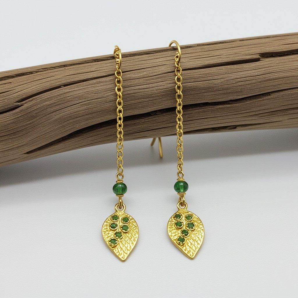 Серьги длинные на цепочках матовое золото мятое. Символ листок с прожилками на нем маленькие зеленые  камушки