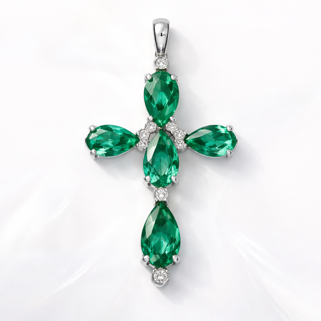 Simple and timeless pear cut emerald white gold cross with minimal diamond accents. Light metal work.