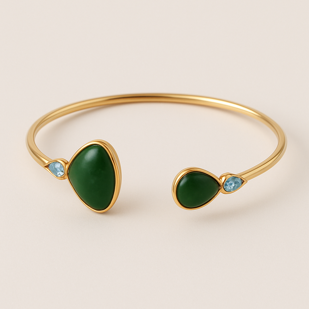 Create a yellow gold cuff with two pear shaped pieces of nephrite jade at the ends and two petite pear shaped blue topaz’s set in the gold of the bracelet