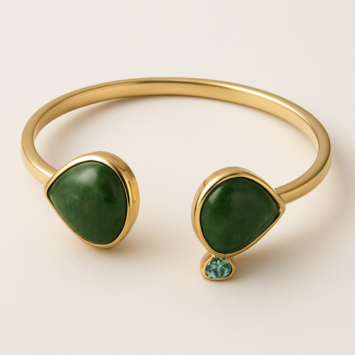 Create a yellow gold cuff with two pear shaped pieces of nephrite jade at the ends and two petite pear shaped blue topaz’s set in the gold of the bracelet
