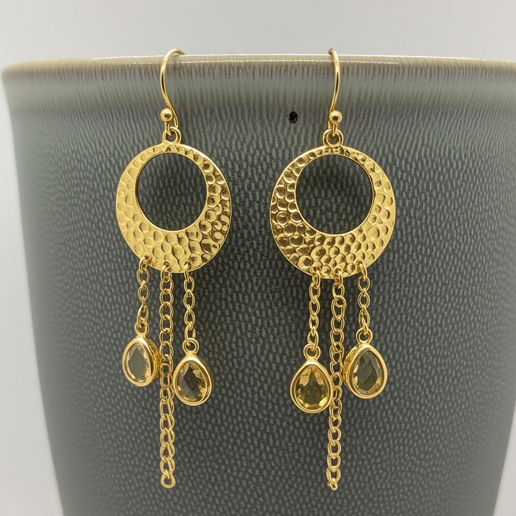 Золотые серьги словно мятое золото в форме узкого изящного полумесяца. Верхушка полумесяца крепится к застежке серьги.  От полумесяца идет три цепочки, у каждой на конце мелкий камушек цитрин