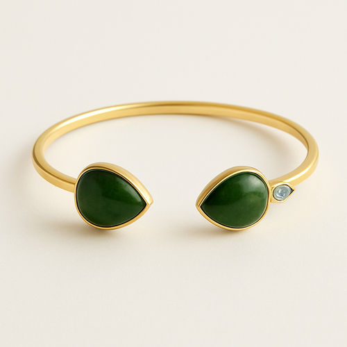 Create a yellow gold cuff with two pear shaped pieces of nephrite jade at the ends and two petite pear shaped blue topaz’s set in the gold of the bracelet