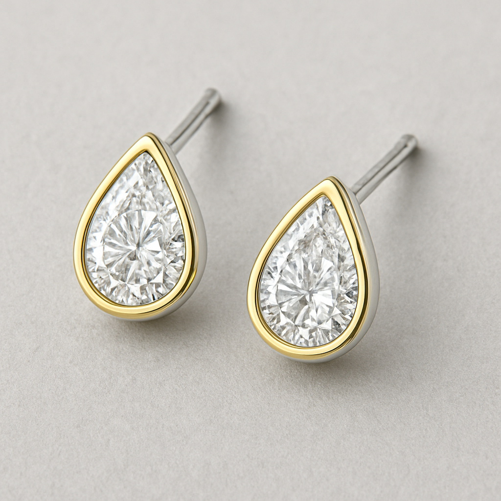 A pear shaped lab grown diamond eraings in white gold a gold borders minimal design