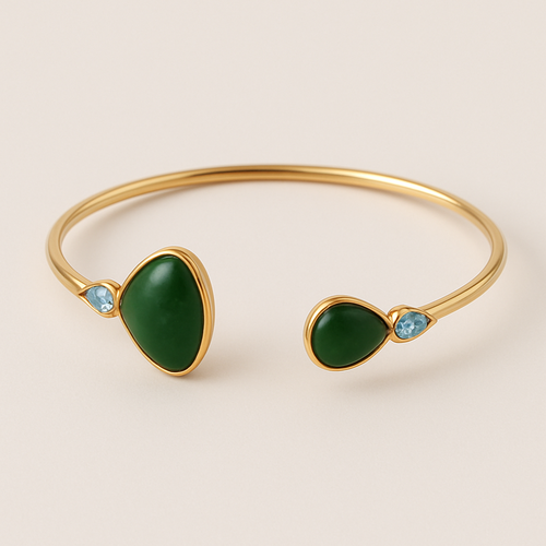 Create a yellow gold cuff with two pear shaped pieces of nephrite jade at the ends and two petite pear shaped blue topaz’s set in the gold of the bracelet